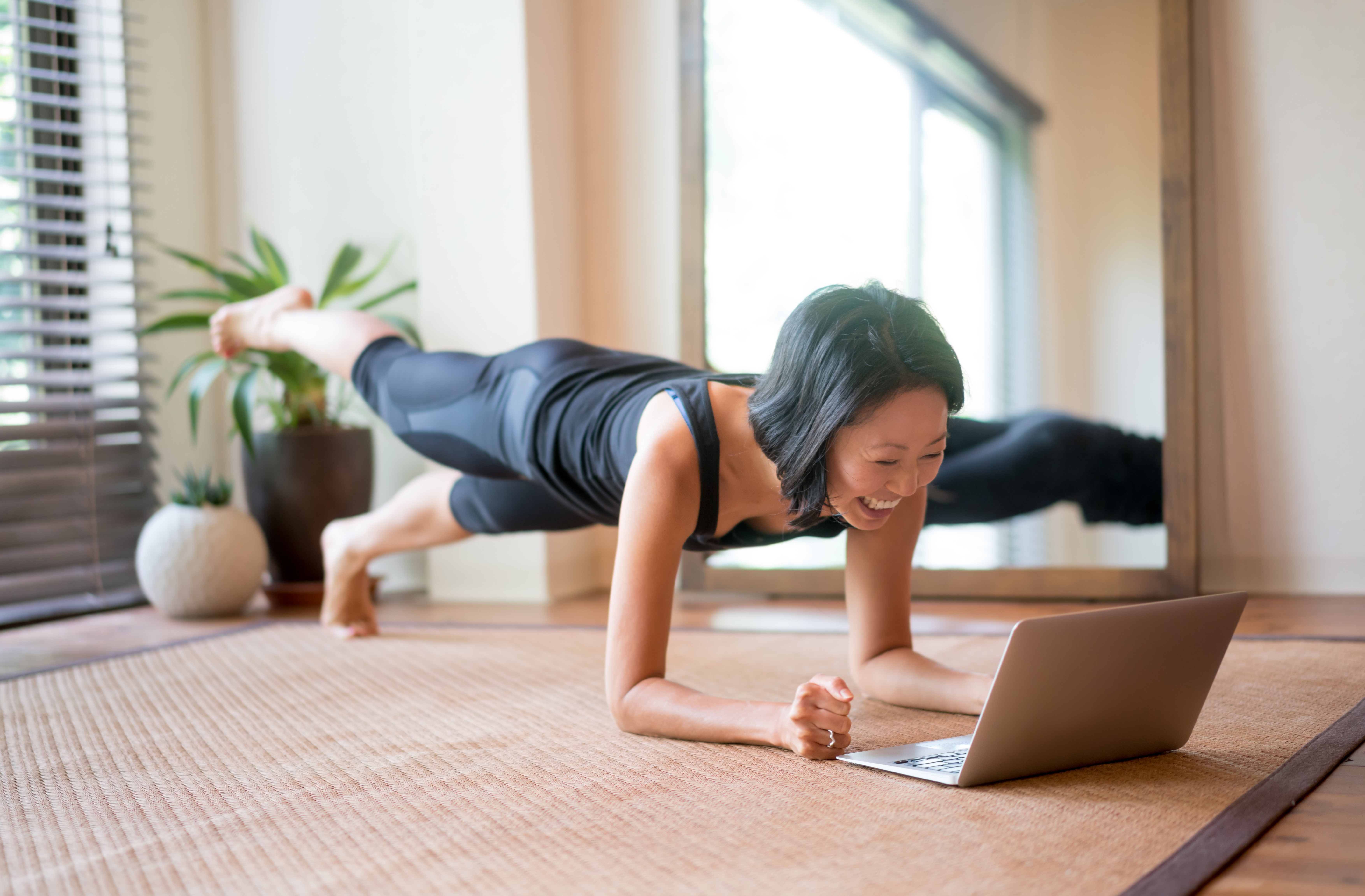 Femme pratiquant le yoga devant son ordinateur portatif
