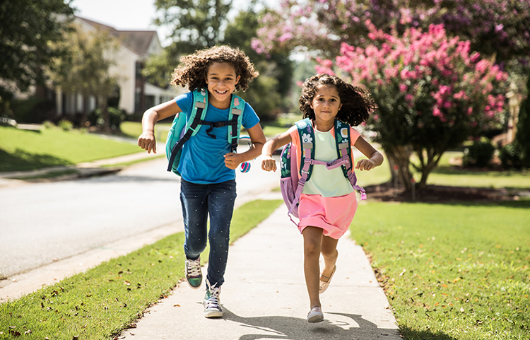 Two little girls running to school